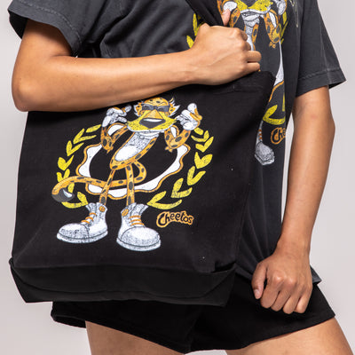 Black canvas tote bag with Chester Cheetah graphic, yellow laurel wreath, 