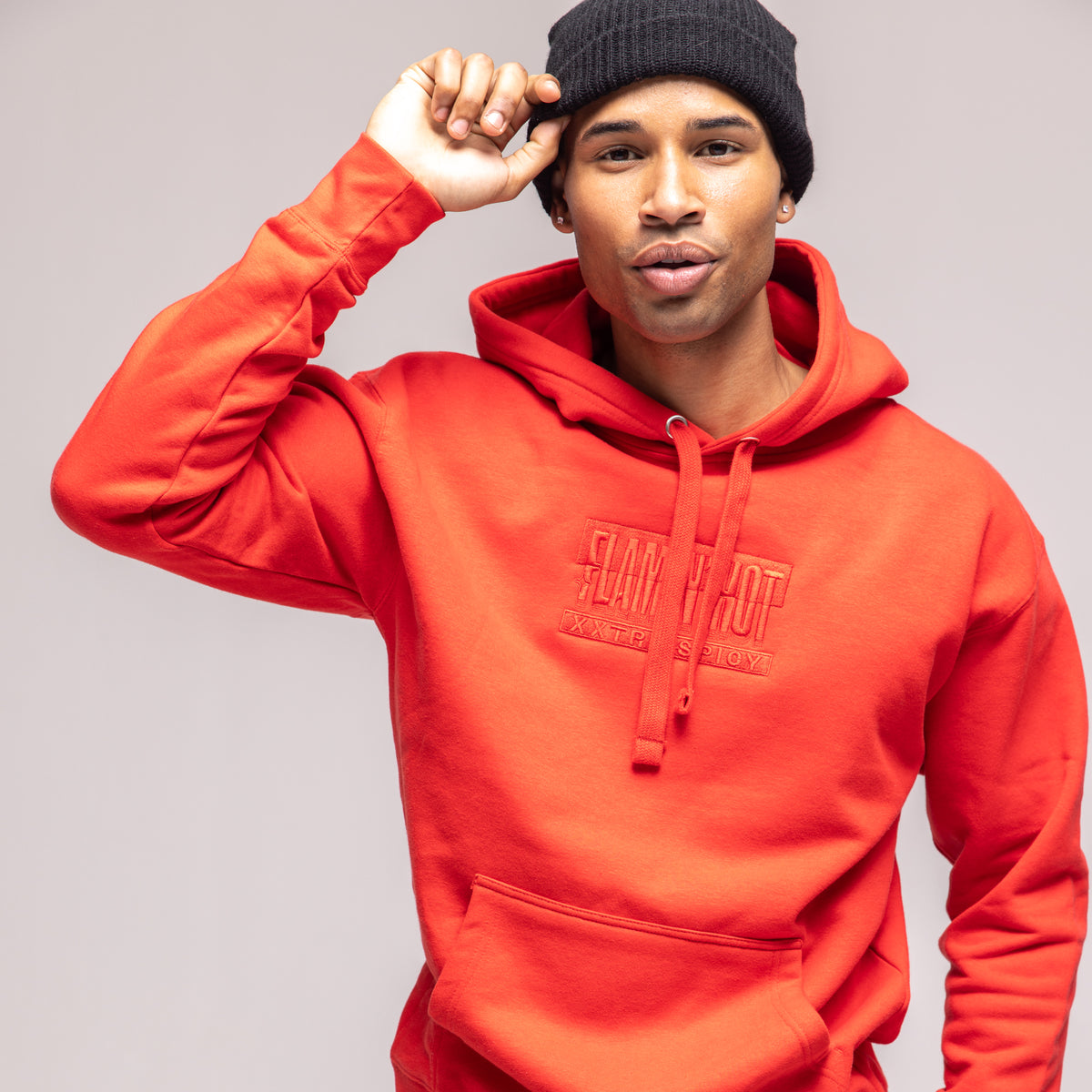 Model in a red hoodie with tonal embroidered 