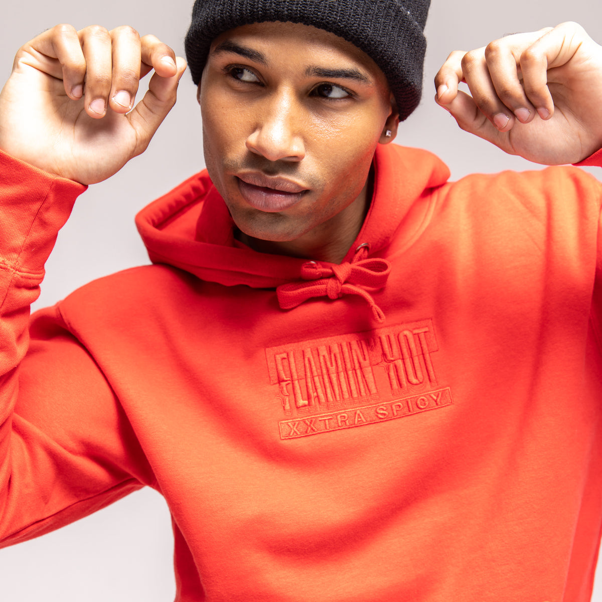 Model in a red hoodie with tonal embroidered 