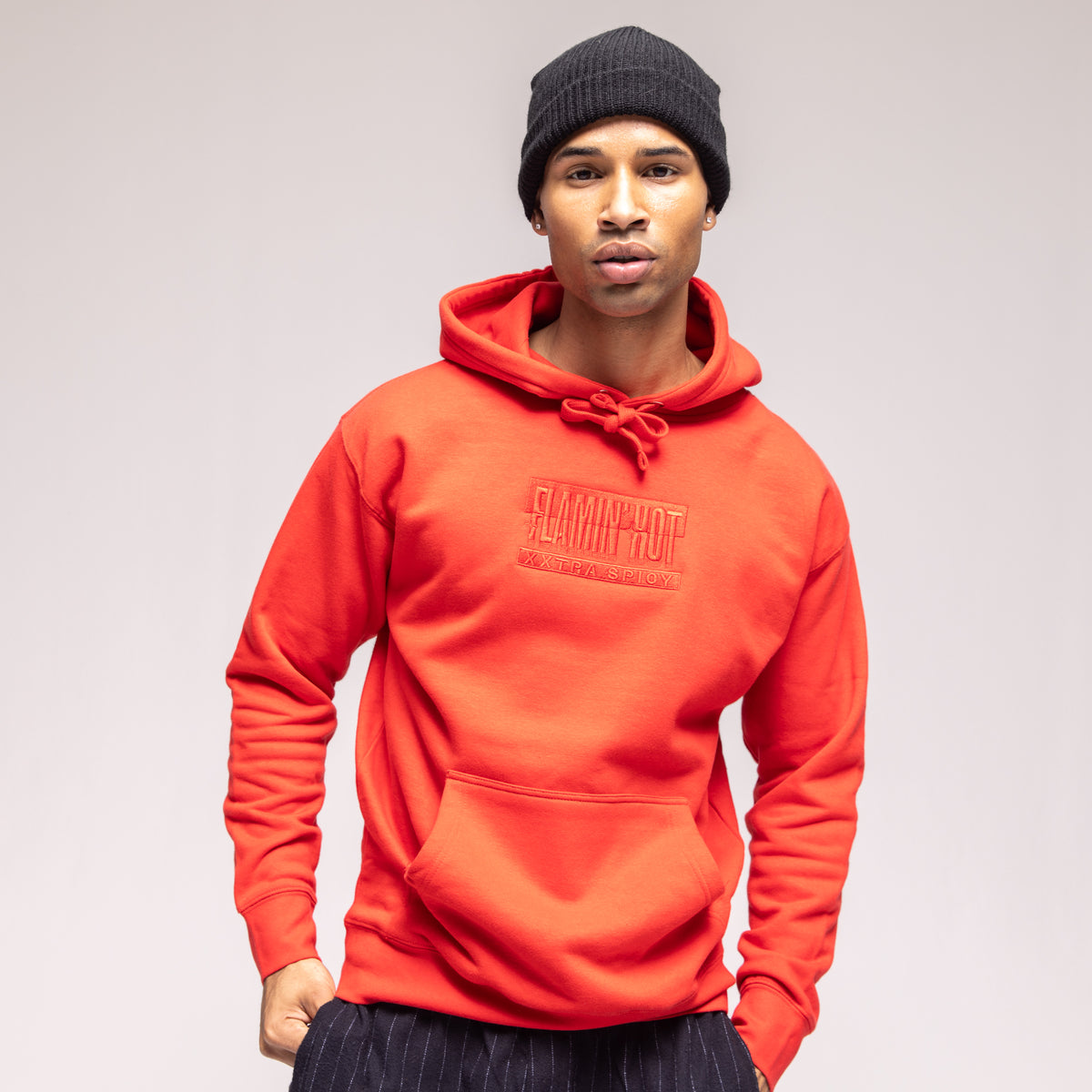 Model in a red hoodie with tonal embroidered 