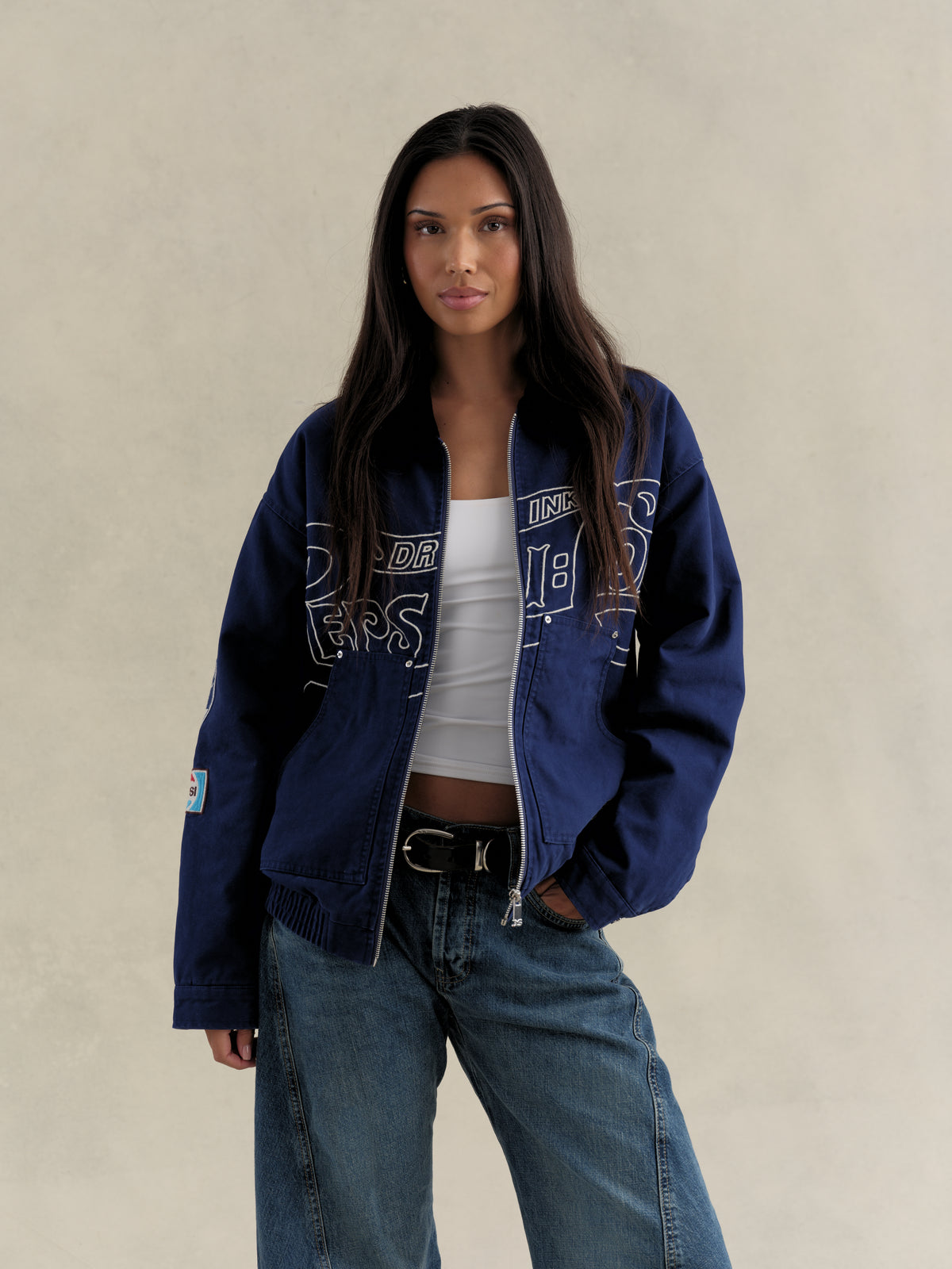 Full-length view of a model in the Pepsi canvas workwear jacket with wide-leg jeans