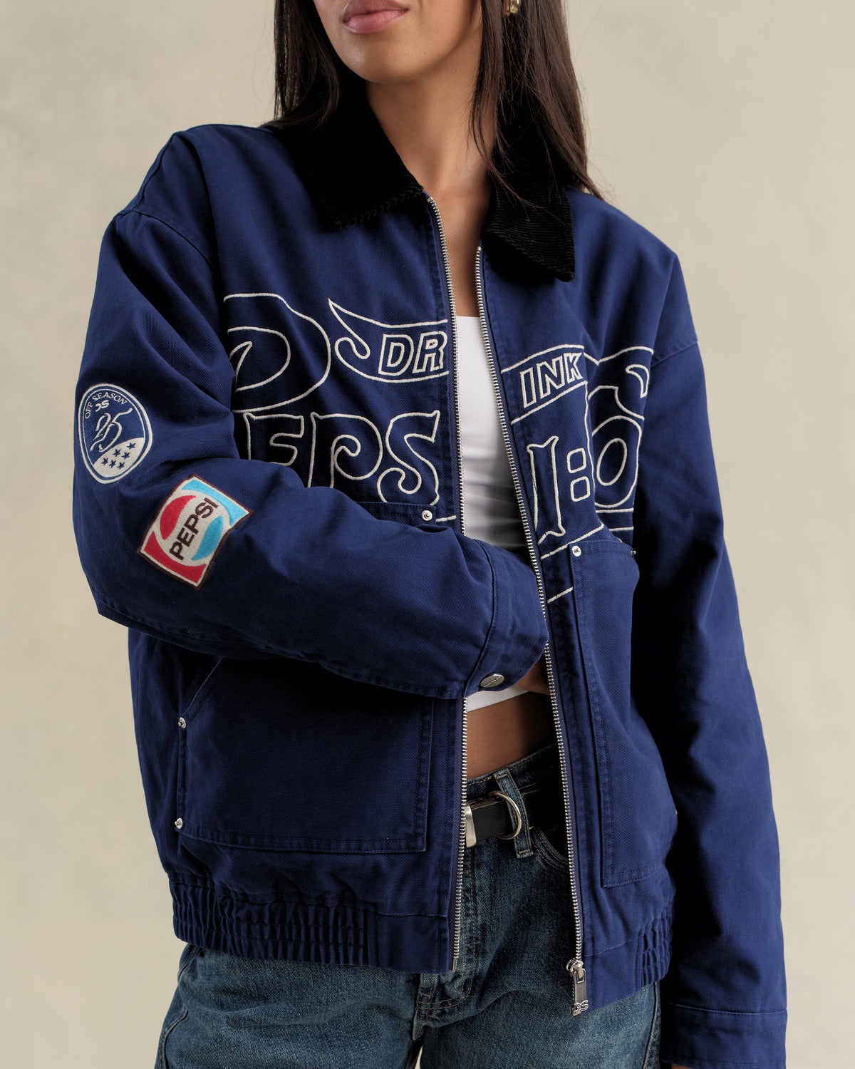 Model wearing the navy Pepsi canvas workwear jacket open over a white top